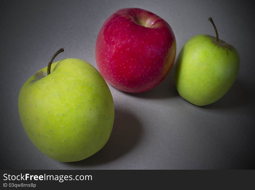 Red Apple Between Two Green Apples