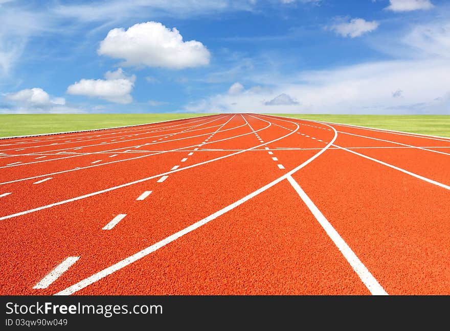 red running track with sky and clouds