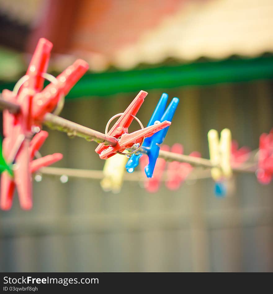 Colorful clothes pegs hanging in the line wire. Colorful clothes pegs hanging in the line wire