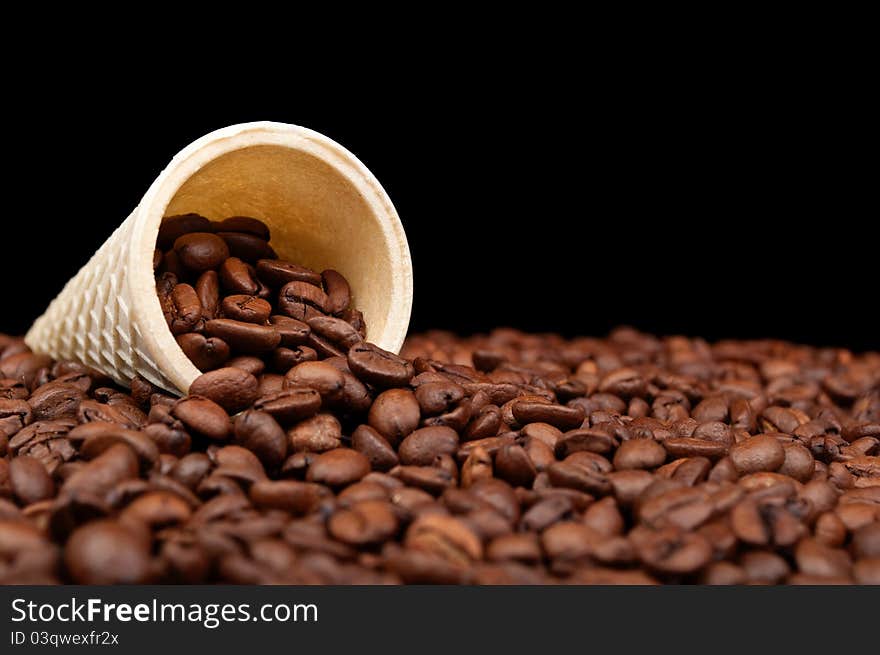 Cone and roasted coffee beans on a black background