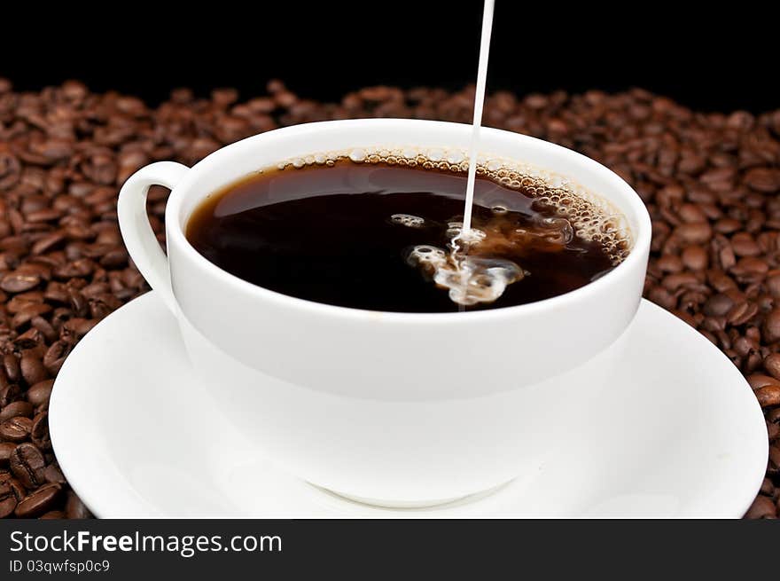 Coffee with milk and coffee beans on a black background