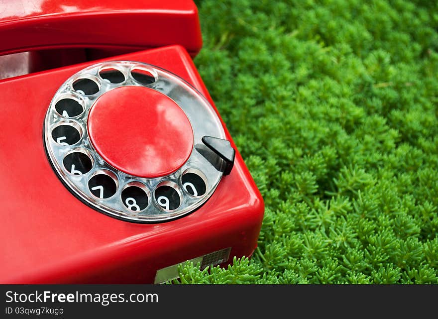 Red phone on green grass