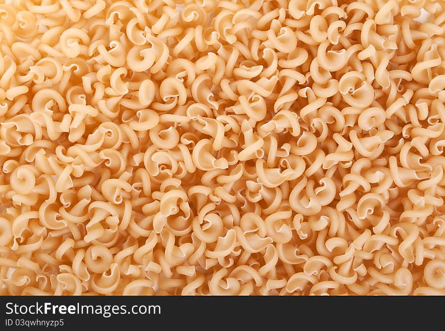 Raw and spiral pasta on a background