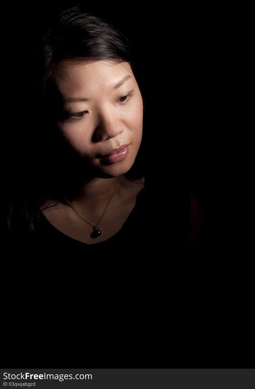 Soft contemplative look of beautiful asian woman on black background. Soft contemplative look of beautiful asian woman on black background