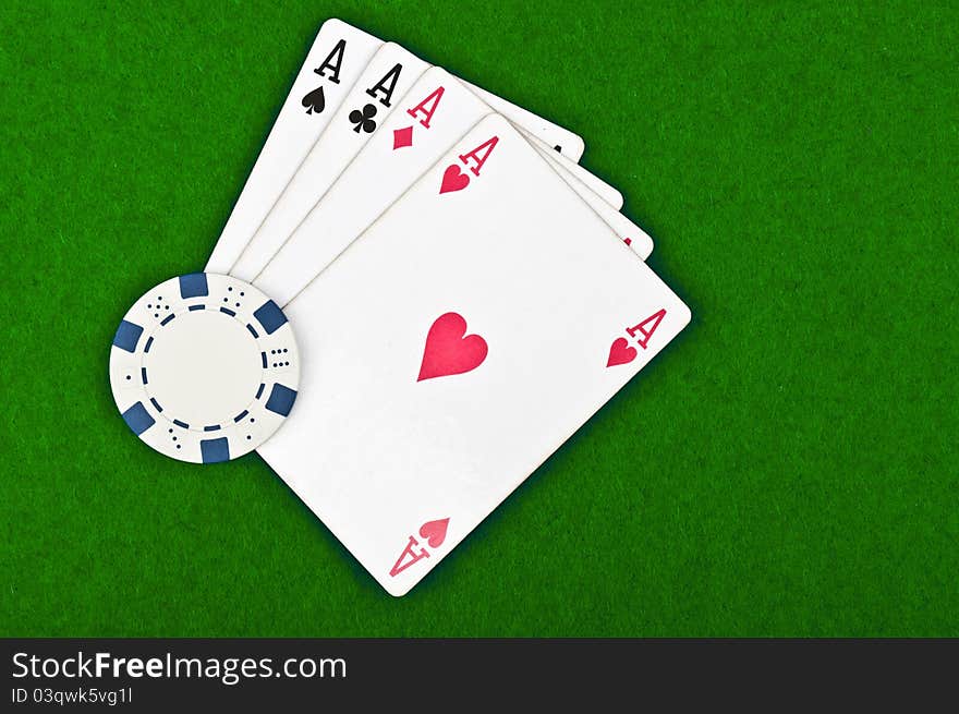 Four aces and poker chips on a green felt