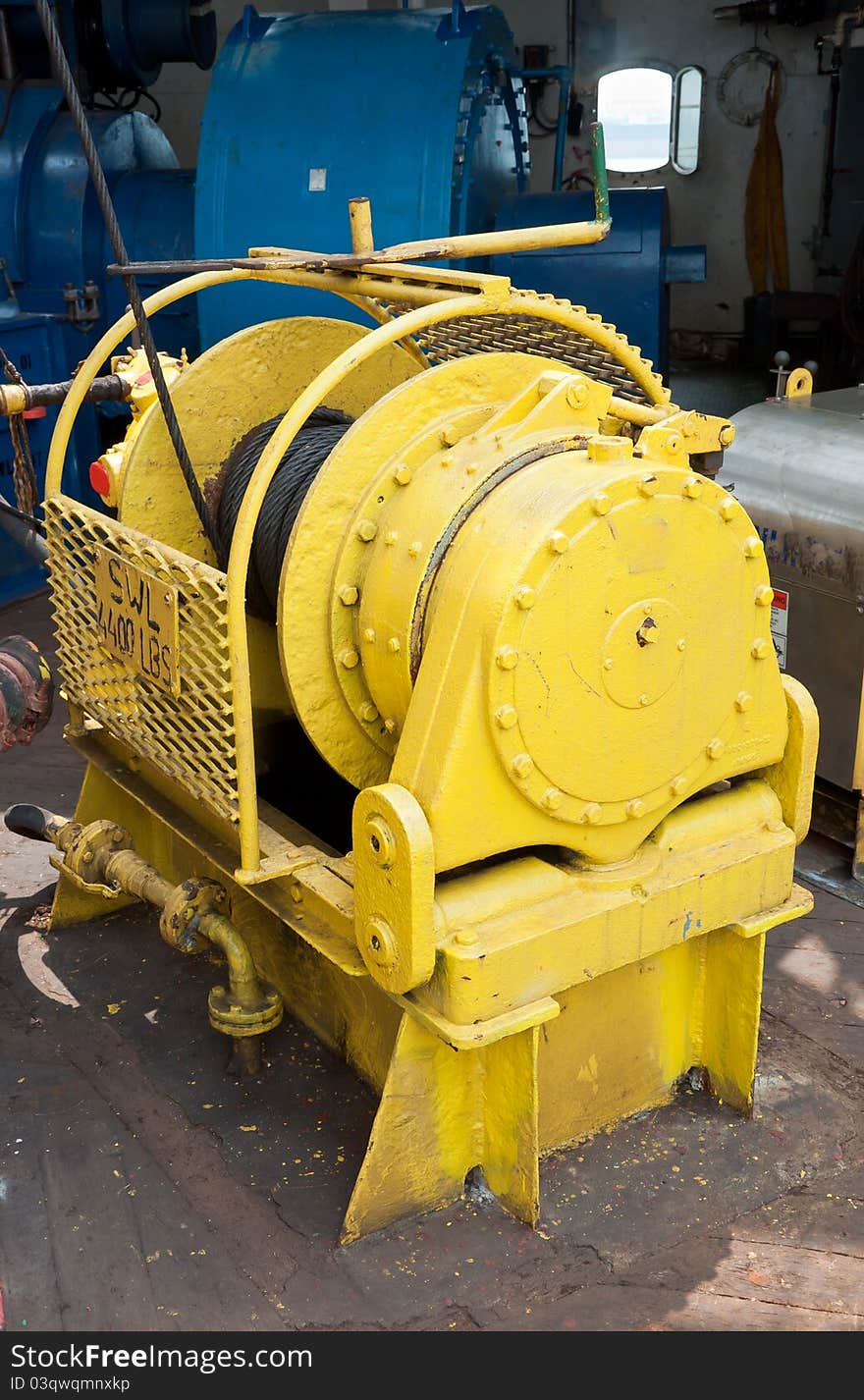 A yellow auxiliary winch on a drill ship dedicated to support handling operations on the drill floor. A yellow auxiliary winch on a drill ship dedicated to support handling operations on the drill floor.