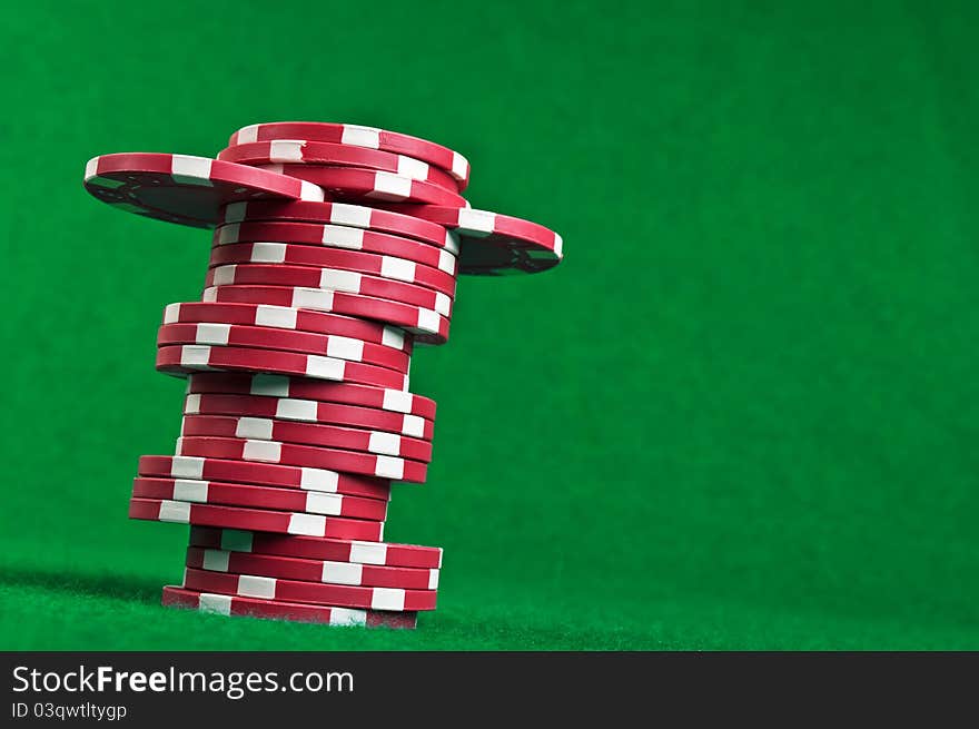 Red poker chips on a green table background