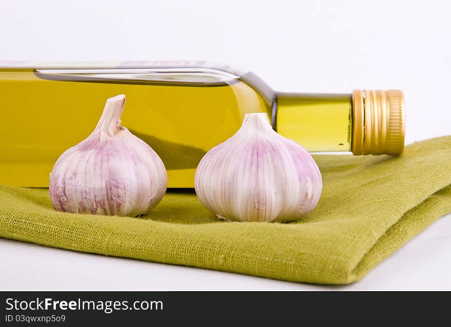 Olive oil and fresh garlic on green texture