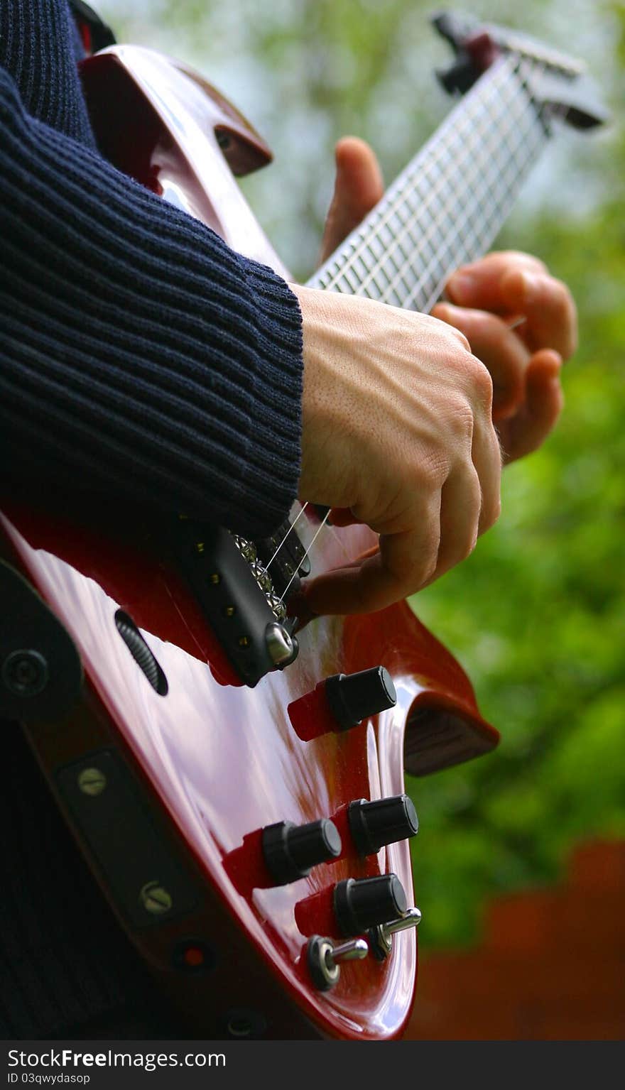 Playing his music with a  red guitar. Playing his music with a  red guitar