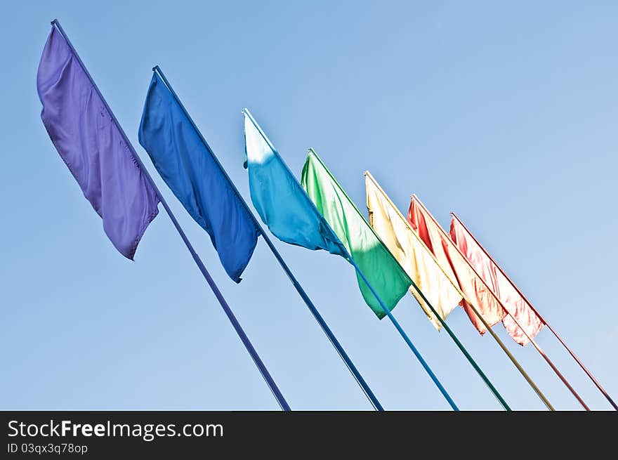 Rainbow colored flags on blue sky background