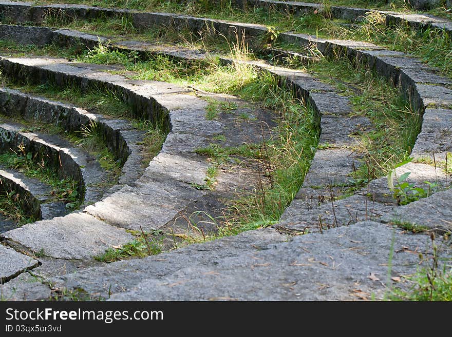 The steps of the old stone stairs in the shape of the amphitheater. The steps of the old stone stairs in the shape of the amphitheater