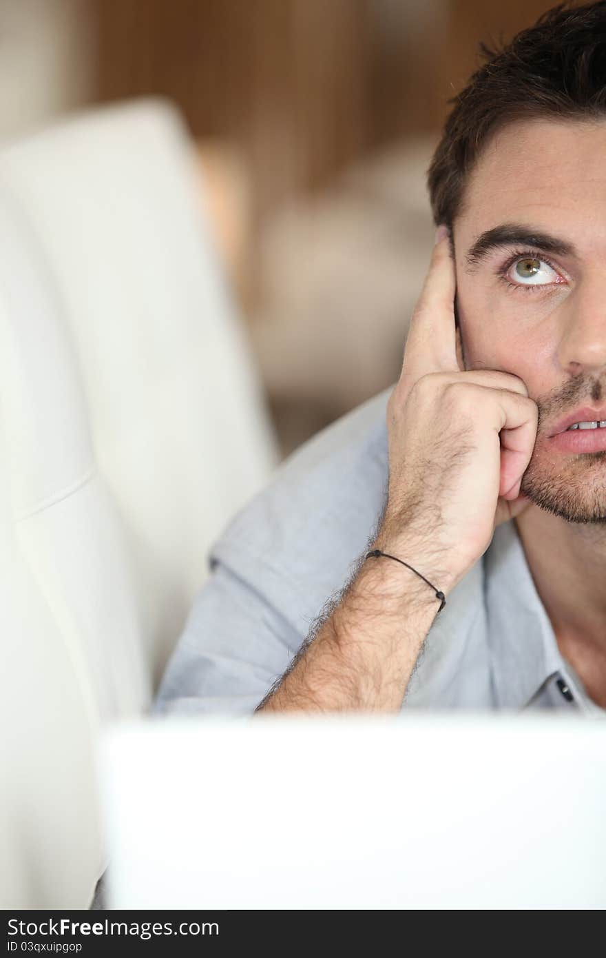 A man looking up behind a laptop