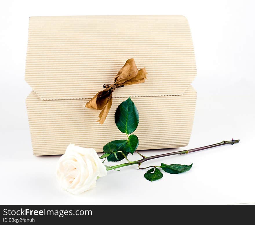 Studio shot of White Gift Box with Gold Bow And White Rose on white background