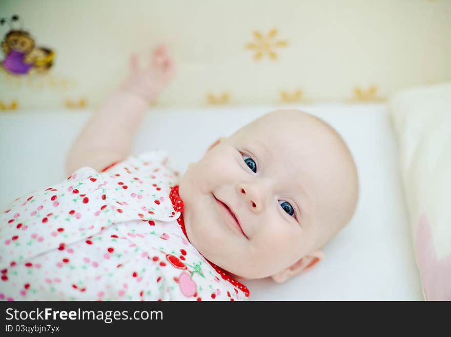 Little beautiful baby girl lying in her bed and smiling. Little beautiful baby girl lying in her bed and smiling