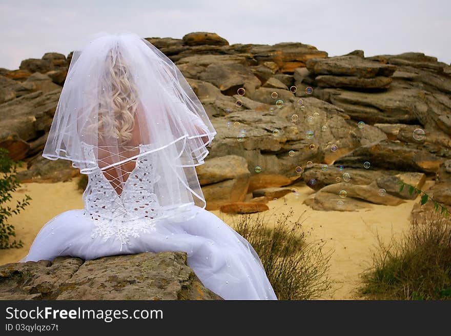 Blowing bubbles bride on the old stones background