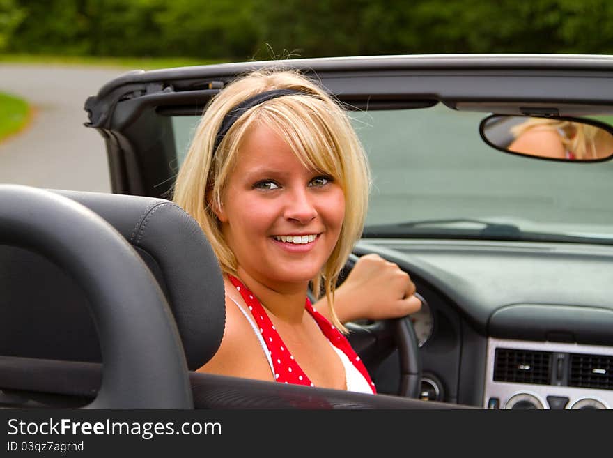 Beautiful woman driver  in open top convertible.