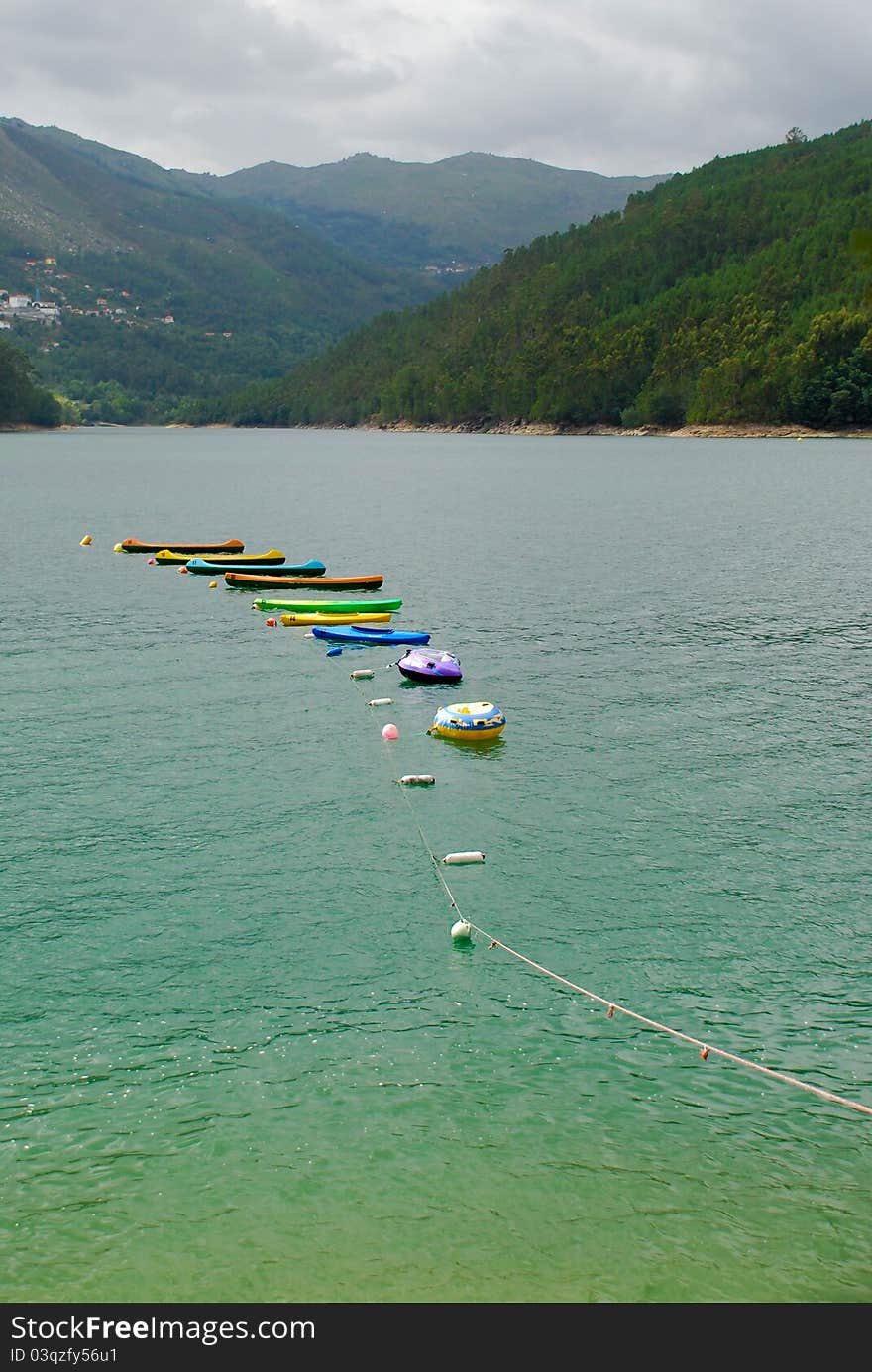 Winter fun in mountain river with colored boats. Winter fun in mountain river with colored boats