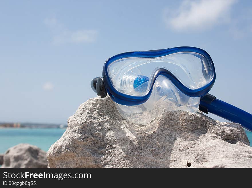 Diving goggles on a rock infront of the sea. Diving goggles on a rock infront of the sea