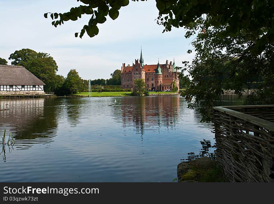 Egeskov castle slot landmark fairy tale castle in Funen Denmark view from the estate lake. Egeskov castle slot landmark fairy tale castle in Funen Denmark view from the estate lake