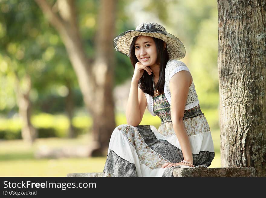 Young smiling asian woman relaxed sitting outdoor. Young smiling asian woman relaxed sitting outdoor