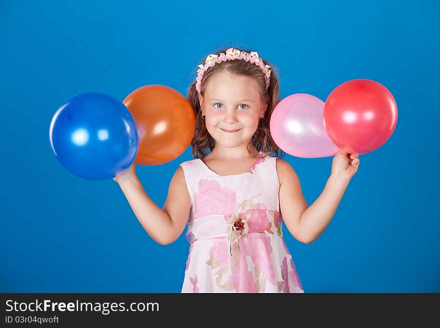 Happy child with colorful air ballons over blue