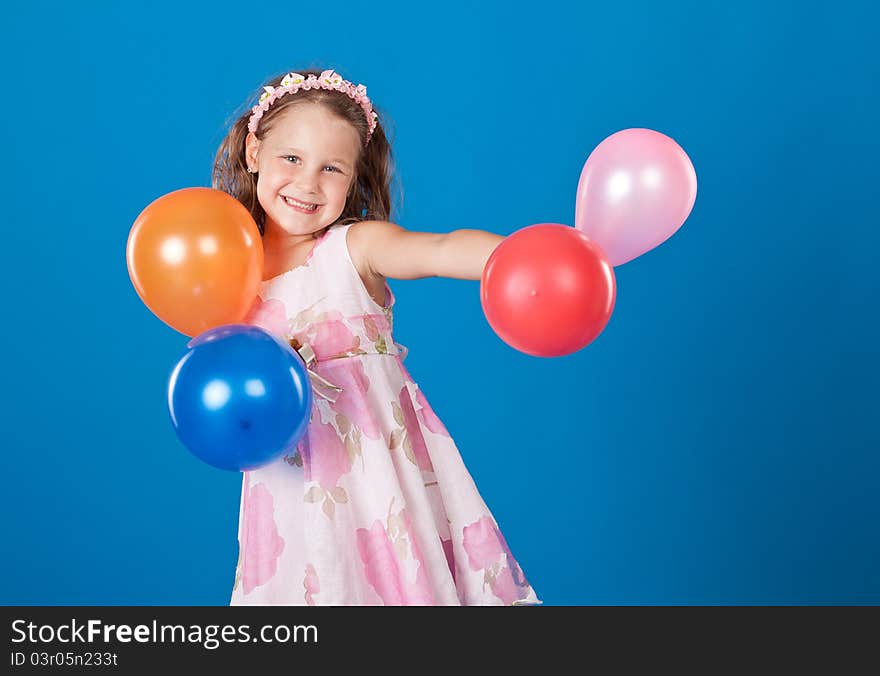 Happy child with colorful air ballons over blue