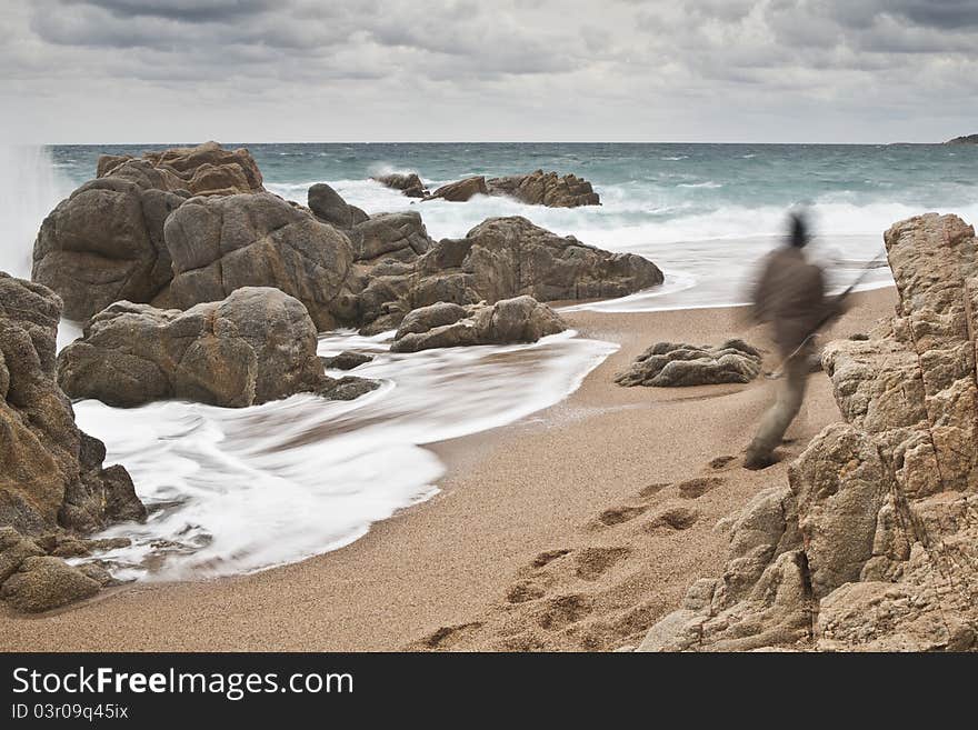 A lonely man is going to fish through the rough sea.