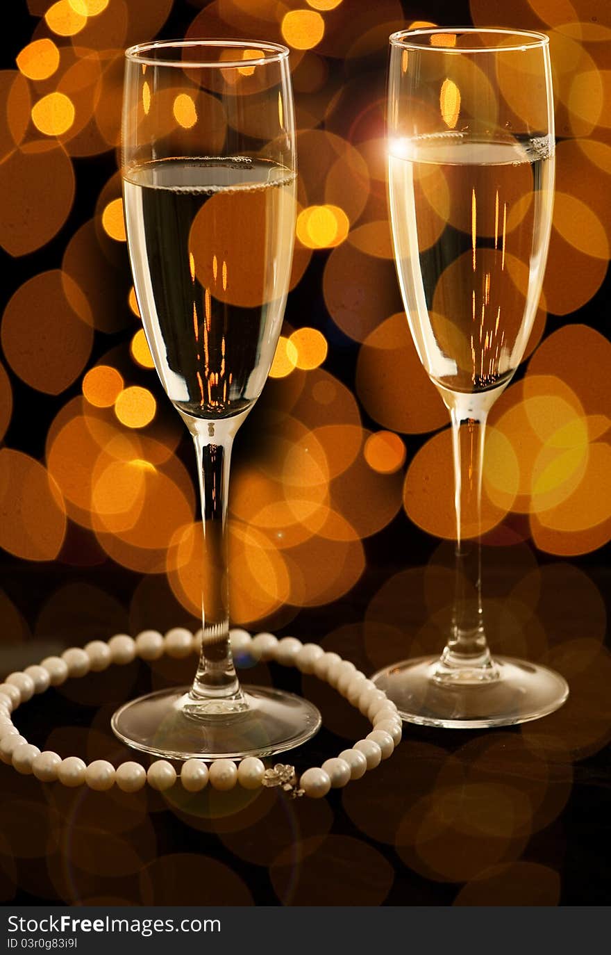 Two glasses of champagne with pearl necklace