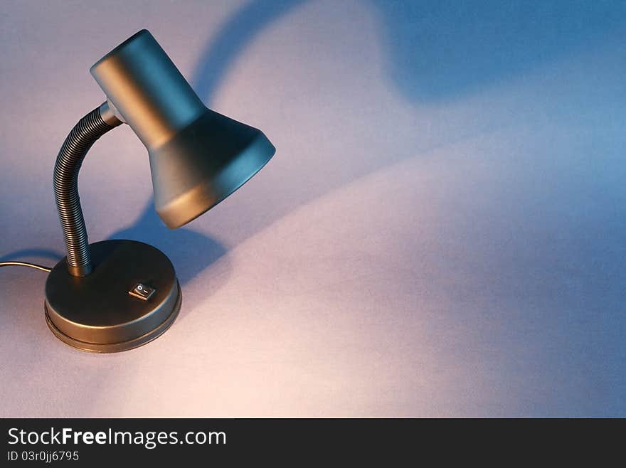 Black luminous desk lamp on dark background with copy space