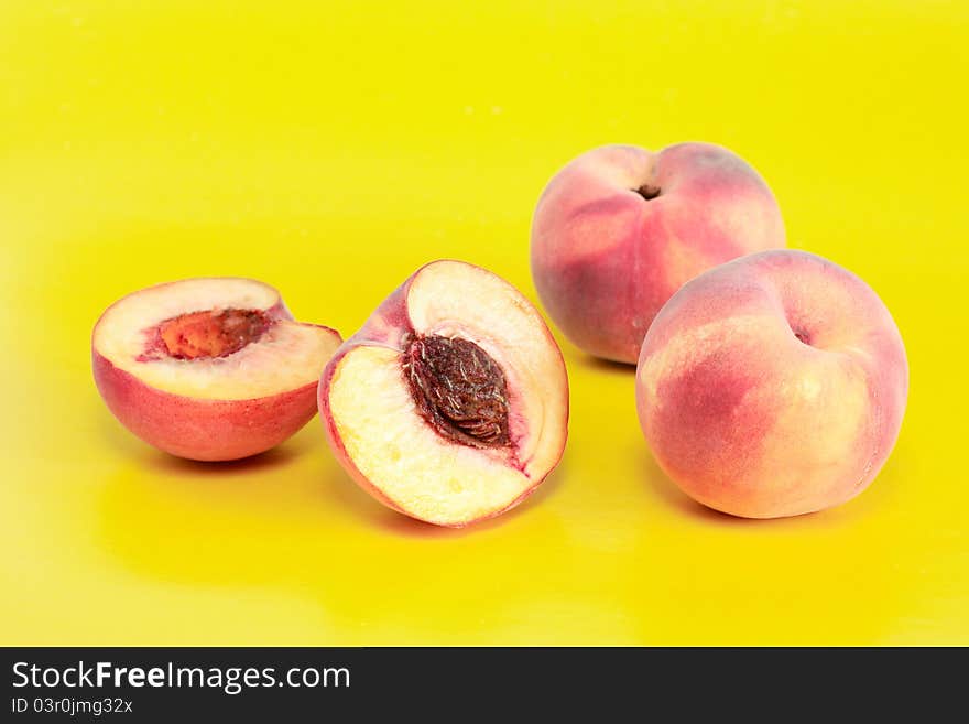 Few peach fruits on yellow background. Few peach fruits on yellow background