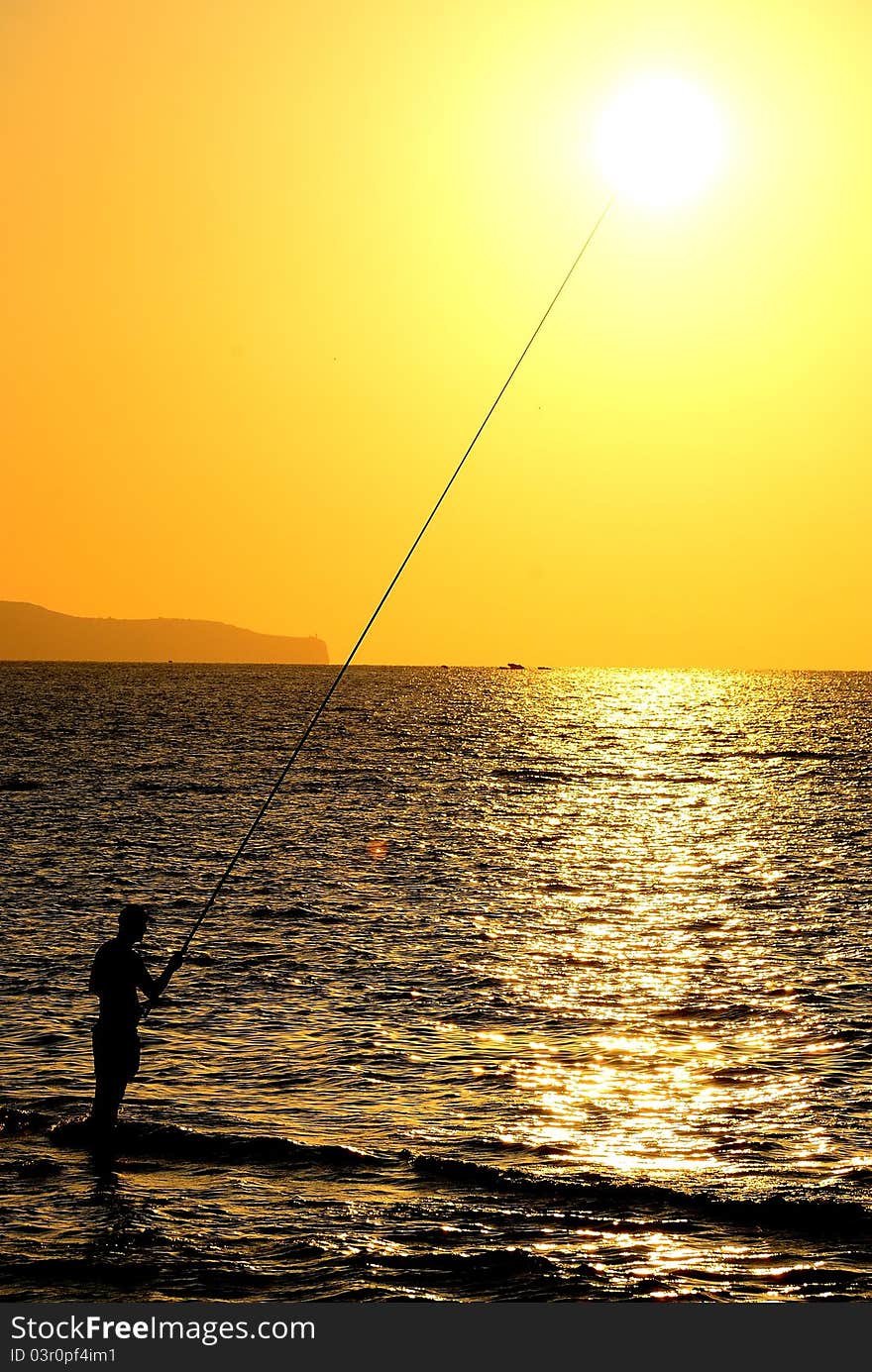 A fisherman at sunset in Sicily
