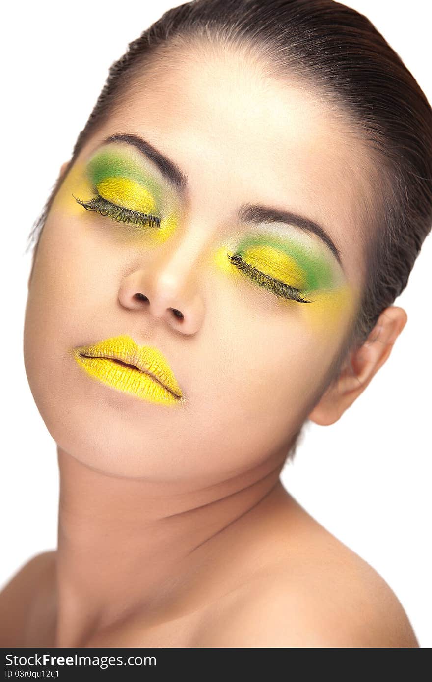 Close up of an Asian female's face wearing yellow and green makeup