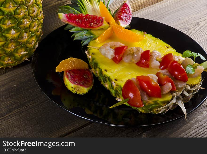 Grilled shrimp spits on ananas decorated with lemon slice, pepper, tomato. Grilled shrimp spits on ananas decorated with lemon slice, pepper, tomato