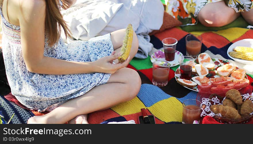 Girl eating sweetcorn at a picnic