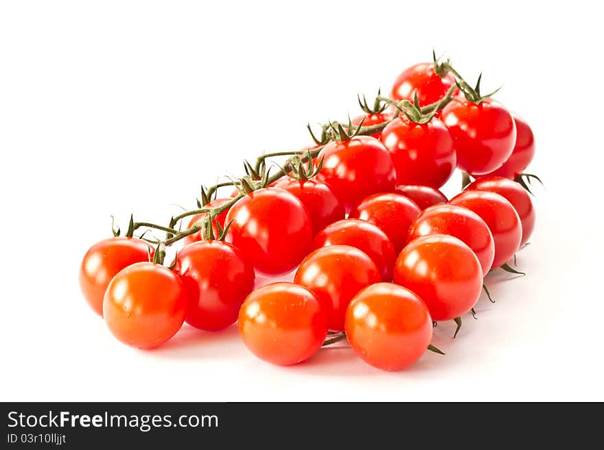 Branch of red cherry tomatoes on a white background