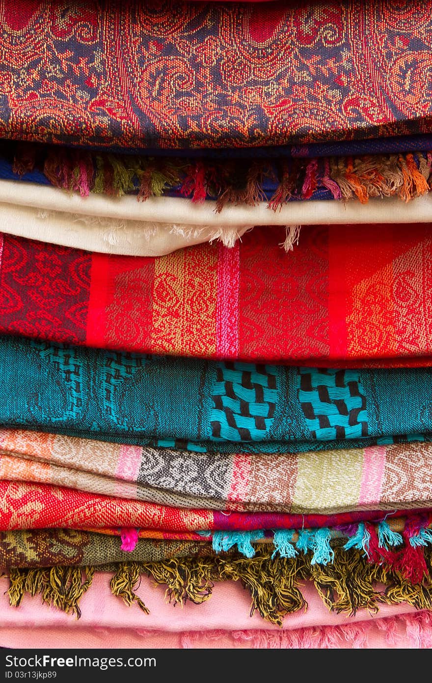 A stack of beautiful colored kashmir scarfs