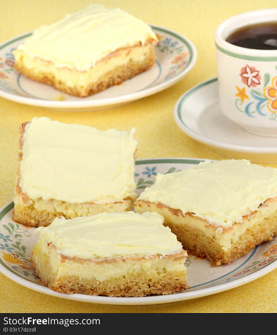 Three dessert lemon bars on a plate and a cup of coffee. Three dessert lemon bars on a plate and a cup of coffee