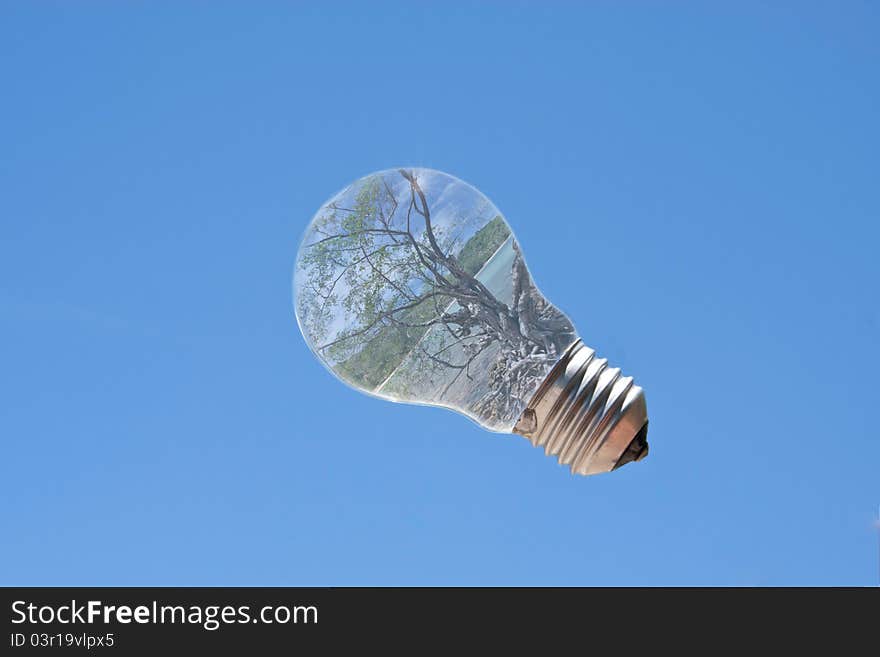 Light bulb with sea landscape inside and sun reflection