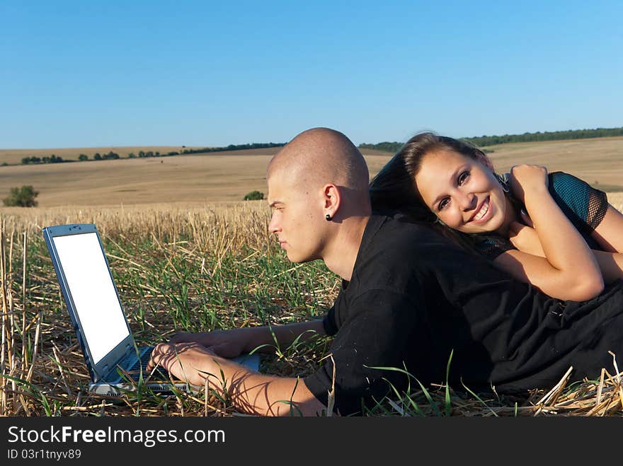 Young men smiling girl noteboks and after working in the field. Young men smiling girl noteboks and after working in the field