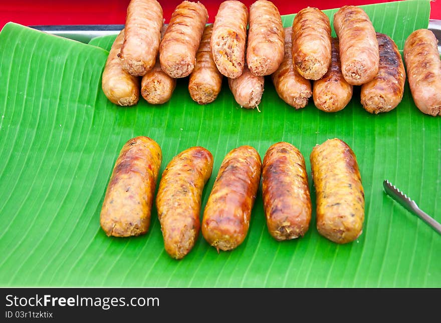 Sausages on banana leaves.