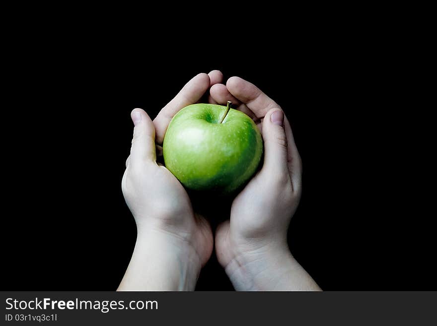 Two hands holding a green apple