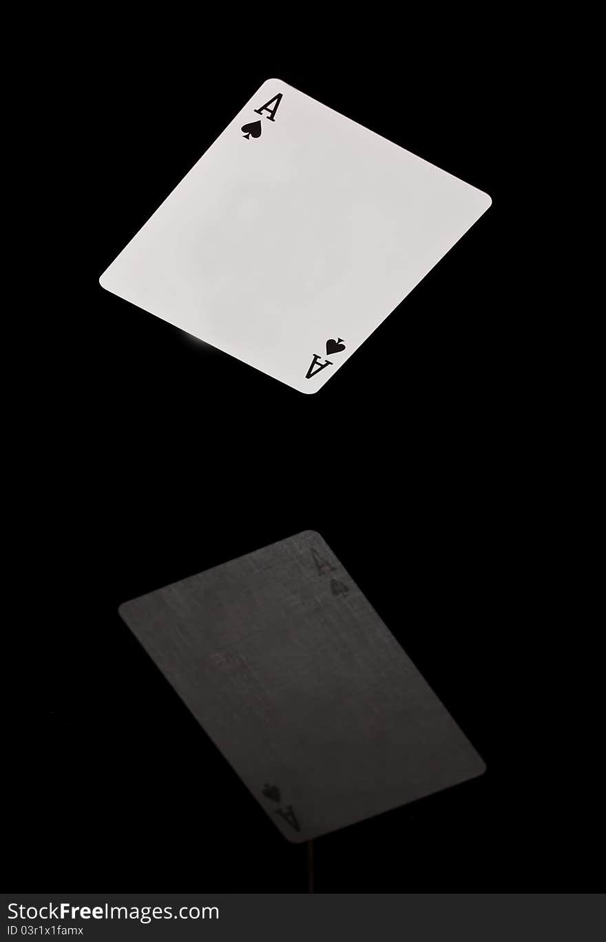 Card falling on black shining surface with reflection