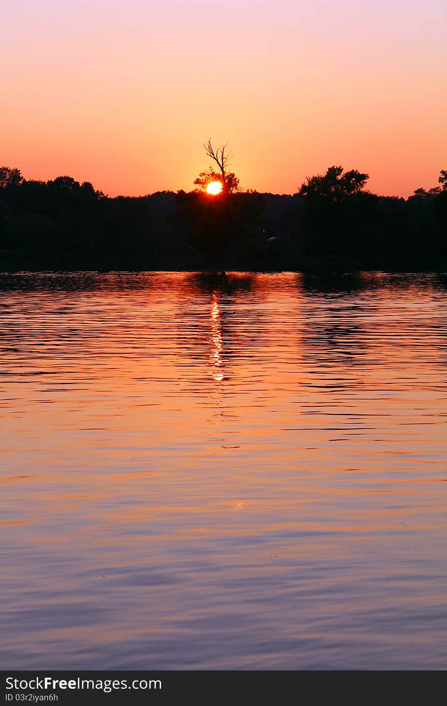 Fiery sunset on the lake in park