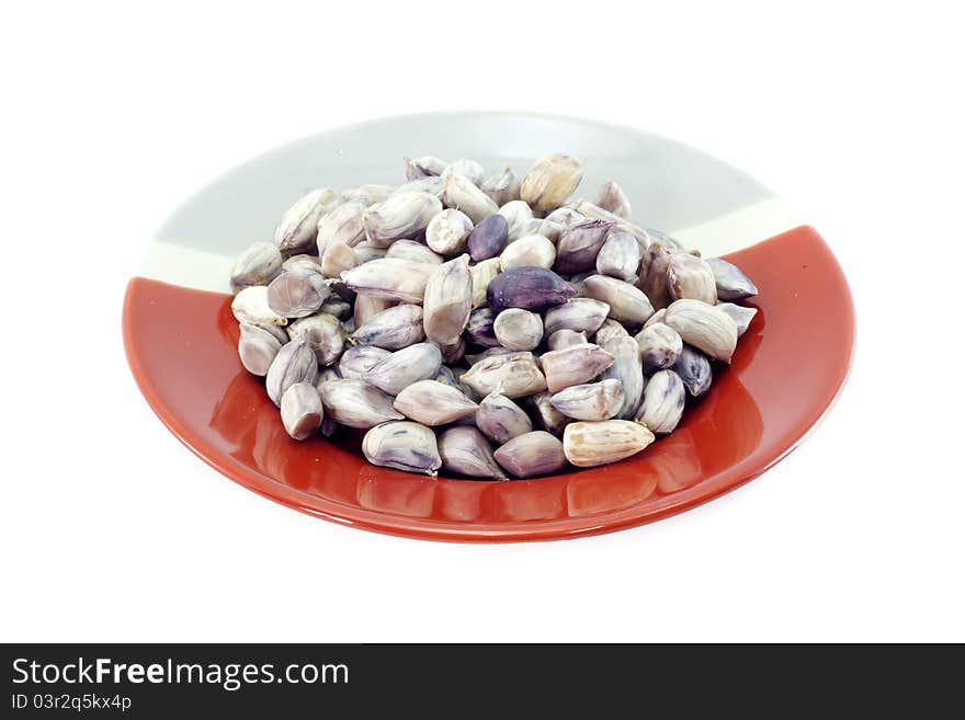 Peanuts on red and gray plate with white background.