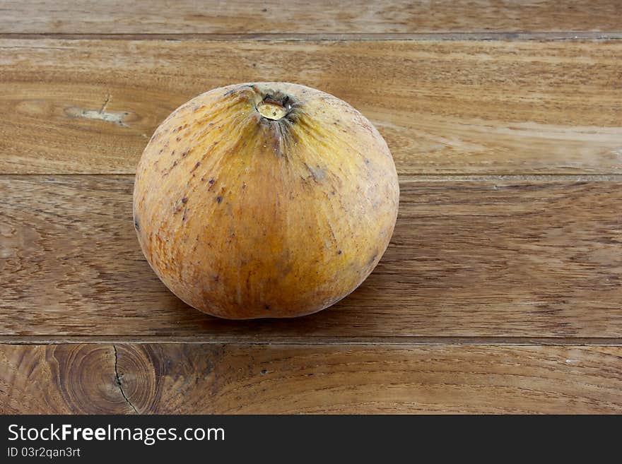 Single santol with teak wood background.