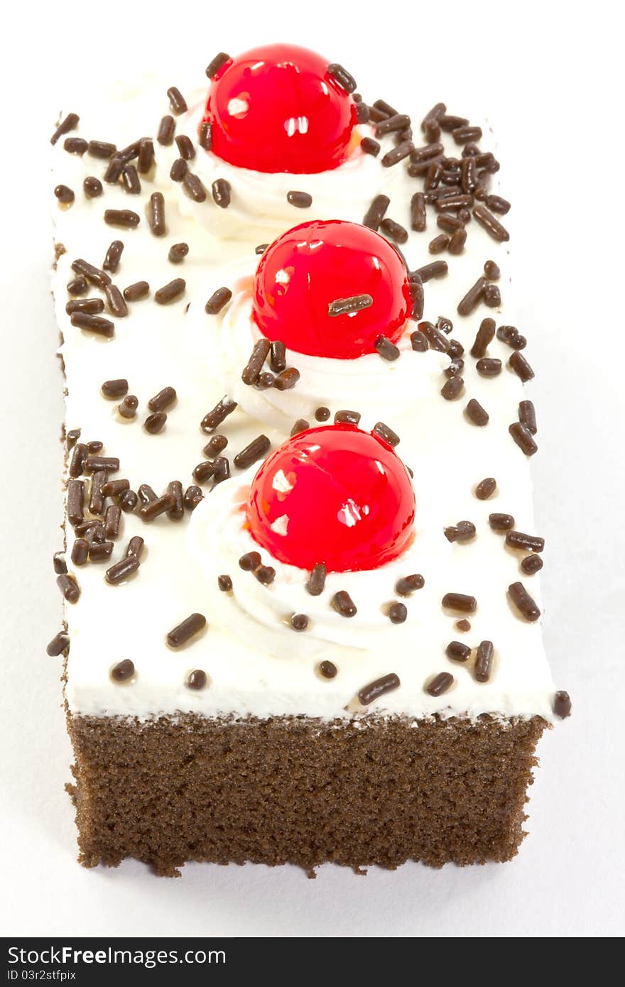 A piece of chocolate cake garnished with cherries and chocolate chips