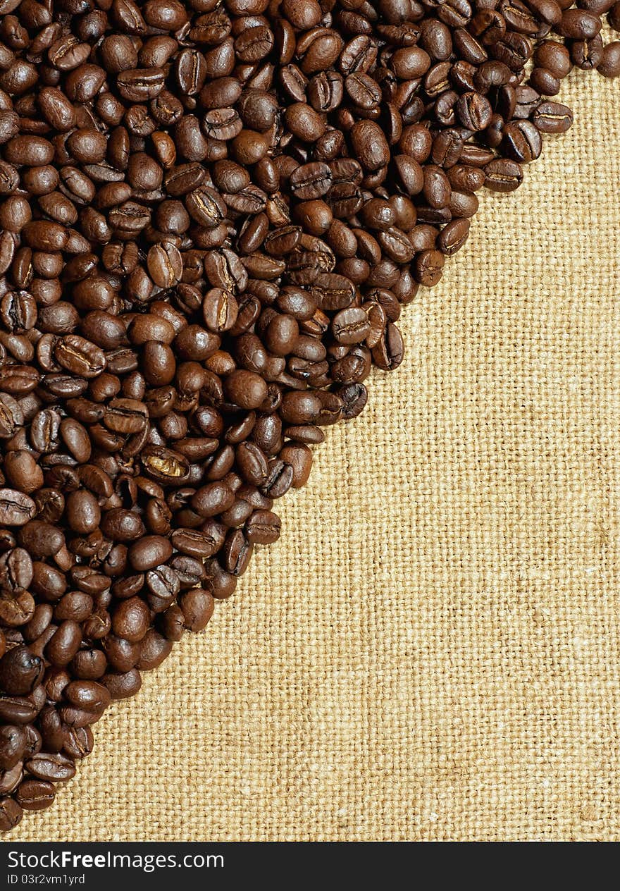 Coffee beans on a burlap texture background