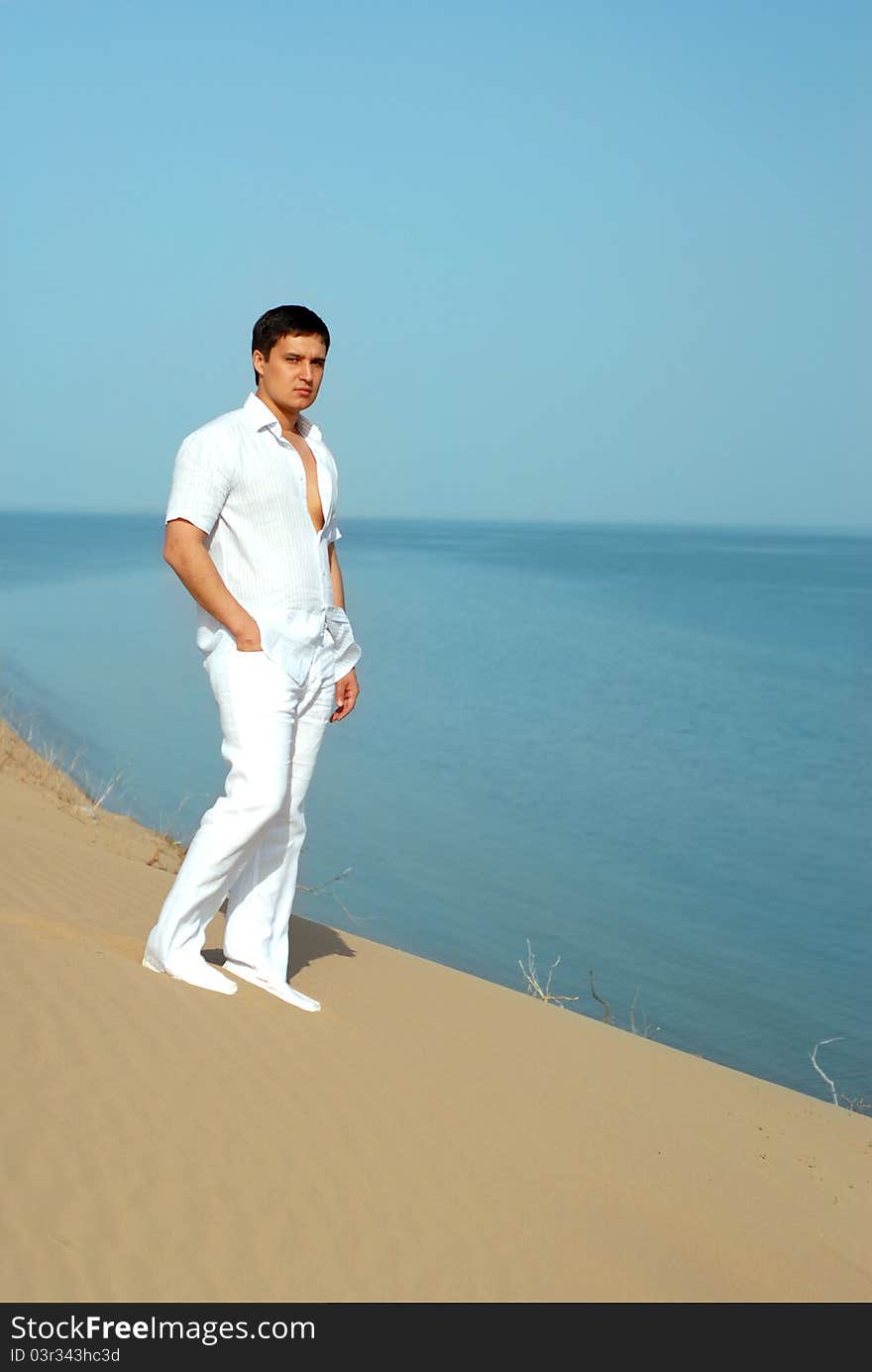 Guy in white robes rising up over the sand dunes and away the sea. Guy in white robes rising up over the sand dunes and away the sea.