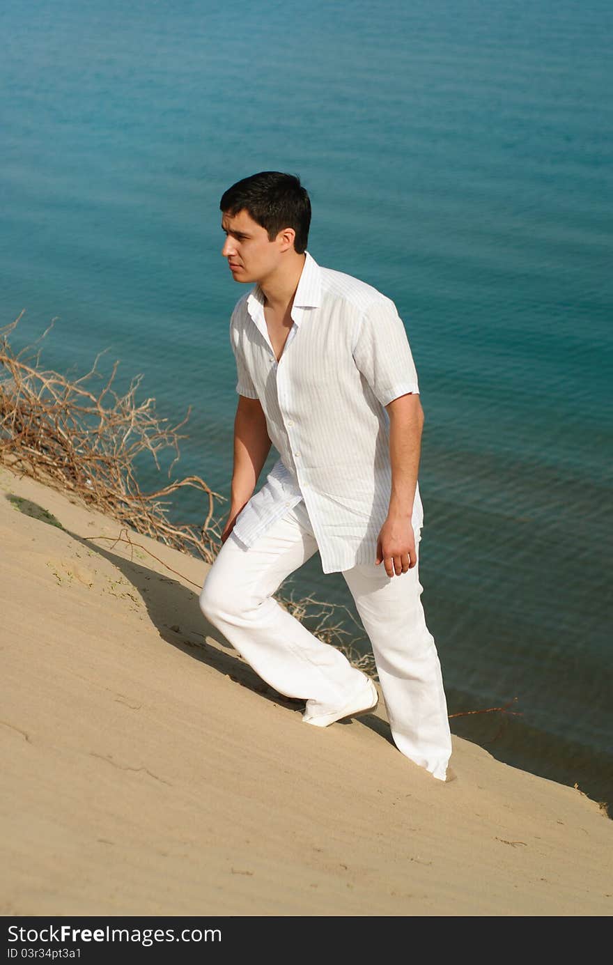 Guy in white robes rising up over the sand dunes and away the sea. Guy in white robes rising up over the sand dunes and away the sea.