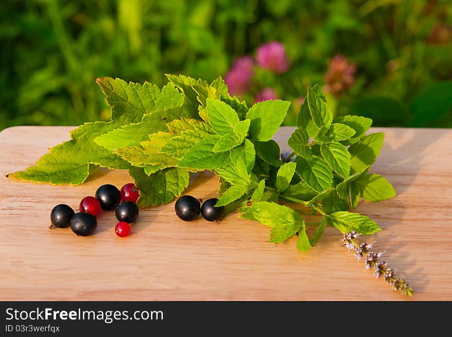 Red and black currants on a wooden board